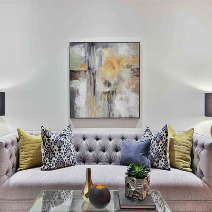 Light coloured couch with purple lamps and a coffee table
